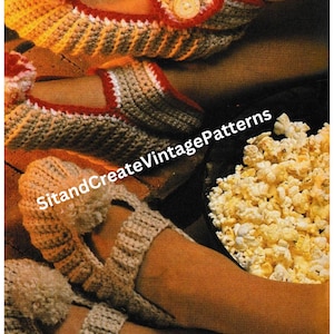 May include: A pair of crocheted slippers with a button detail. The slippers are beige with red and white trim. The slippers are being worn by someone sitting by a fireplace with a bowl of popcorn.