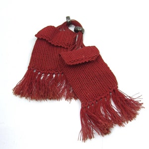 May include: Two red crocheted tassels with fringe, each with a silver ring at the top.