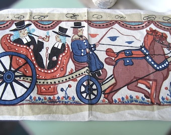 May include: A rectangular linen tea towel featuring a colorful screen-printed illustration of a horse-drawn carriage with two passengers in black hats and coats, a driver, and floral motifs in shades of red, blue, and black on a cream background.