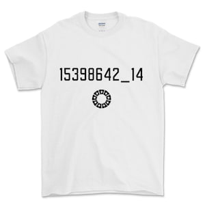 Può includere: T-shirt bianca con la scritta nera "15398642_14" e un disegno circolare nero sottostante. La maglietta è a girocollo e sembra essere di cotone.