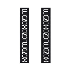 May include: Two black rectangular fabric strips with white text reading "XOZDRTOJZOX". The text is vertically aligned and centered on the strips. The background is plain white.