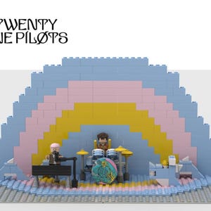 Peut inclure: Un ensemble de scène Lego représentant le groupe Twenty One Pilots. La scène est construite avec des briques bleues, roses et jaunes, ressemblant à un arc-en-ciel. Comprend des figurines miniatures des membres du groupe et leurs instruments.