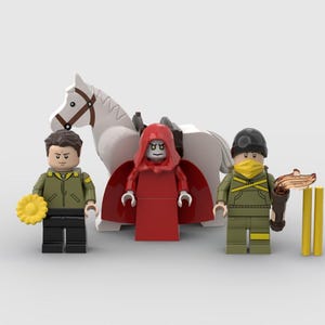 May include: A Lego scene featuring three minifigures and a white horse. One minifigure wears a red hooded robe, another a green jacket and black pants, and the third a green uniform with a yellow mask. Accessories include a torch and a yellow flower.