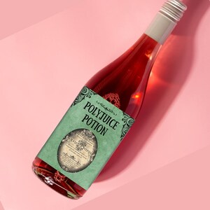 May include: A glass bottle of red liquid with a green label that reads "Polyjuice Potion". The label has a vintage design with ornate lettering and a circular image of a potion bottle.