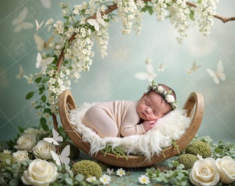 May include: A newborn baby sleeping in a crescent-shaped wooden cradle decorated with white flowers and butterflies. The cradle is nestled in a bed of white faux fur and surrounded by greenery.