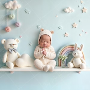 Könnte beinhalten: Ein weißes Regal mit einem Regenbogen, einem weißen Hasen, einem weißen Teddybär und einem Baby in einem weißen Strickoutfit. Das Regal ist mit Wolken und Sternen verziert.