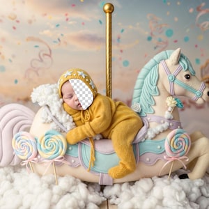 May include: A sleeping baby in a yellow outfit and hat rests on a carousel horse. The carousel horse is white with blue and lavender accents, and is decorated with lollipops. The background features a dreamy sky with confetti and a carousel.