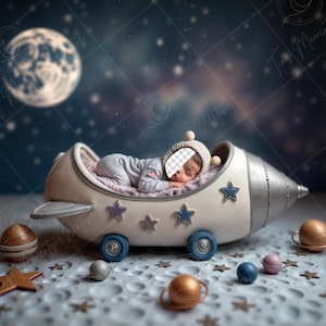 May include: A sleeping baby in a gray onesie and hat rests in a cream-colored rocket ship bed with blue wheels and star accents. The scene is set against a starry night sky with a large moon and decorative planets.