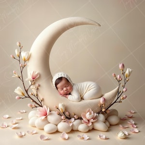 Könnte beinhalten: Ein Neugeborenes schläft auf einer weißen Halbmond-Requisite, die mit weißen und rosa Blumen verziert ist. Das Baby trägt einen weißen Strampler und eine weiße Strickmütze.