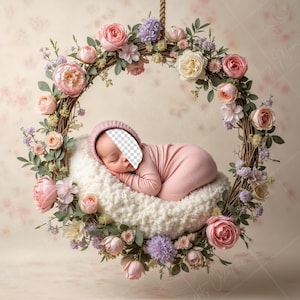 May include: A sleeping baby in a pink onesie is nestled in a white, fluffy nest. The nest is suspended from a floral wreath made of pink, white, and purple flowers.