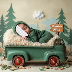 May include: A green toy truck with a white furry bed in the back. A baby is sleeping in the bed, wearing a green knitted outfit. The truck is in front of a green forest backdrop with a sign that reads "Adventure Ahead".