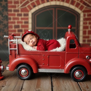 May include: A red toy fire truck with a white fluffy bed in the back. A baby wearing a red and white fireman's hat is sleeping in the bed.