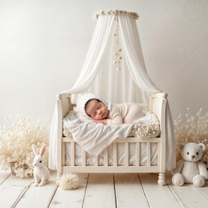 May include: A sleeping baby in a cream-colored outfit and hat rests in a vintage-style crib with a canopy. The crib is surrounded by white decorative elements, including a stuffed bear, a rabbit figurine, and dried flowers.