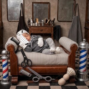 Pode incluir: Um bebê vestido de barbeiro dorme em uma poltrona listrada em um ambiente de barbearia vintage. A cena inclui ferramentas de barbeiro como tesouras, pentes e um pincel de barbear. Um poste de barbeiro clássico com listras vermelhas, brancas e azuis está por perto.