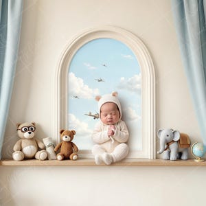 May include: A newborn baby wearing a white knitted outfit with bear ears sits in front of a window with a blue sky and clouds. The baby is looking up and has its hands clasped together. There are three stuffed animals on a shelf below the window: a brown bear with glasses, a brown bear with no glasses, and a gray elephant with a brown saddle.
