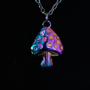 May include: A rainbow iridescent mushroom pendant necklace. The mushroom is a light purple and blue color with yellow dots. The chain is silver.