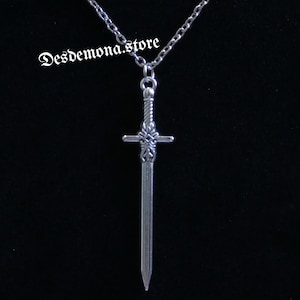 May include: A silver sword pendant necklace with a chain. The sword has a detailed hilt and a pointed tip.