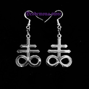 May include: A pair of silver earrings featuring the Leviathan cross symbol, a symbol associated with Satanism.
