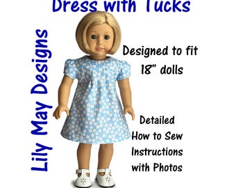 Pode incluir: Um vestido floral azul e branco com pregas para bonecas de 45,7 cm. O vestido é projetado para se ajustar às bonecas e inclui instruções de costura detalhadas com fotos. "Lily May Designs" está escrito verticalmente no lado esquerdo da imagem.