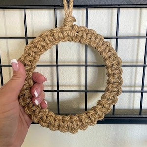 May include: A brown rope wreath with a loop at the top for hanging.