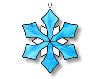 May include: A blue stained glass snowflake ornament with a white center. The snowflake has a loop at the top for hanging.