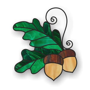 May include: A stained glass design featuring a green oak leaf with two brown and beige acorns. The leaf has a marbled pattern and the acorns have a swirl design.