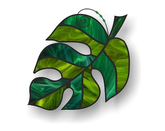 May include: A stained glass leaf in shades of green, with a swirl design at the top.