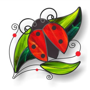 K&ouml;nnte beinhalten: Eine Glasmalerei-Marienk&auml;fer mit roten und schwarzen Fl&uuml;geln, umgeben von gr&uuml;nen Bl&auml;ttern und roten Beeren.