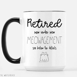 May include: White ceramic mug with a black handle and rim. The mug features the text "Retired now under new MEOWAGEMENT see below for details" in black, along with a cat illustration. The mug is 15oz.