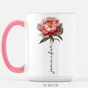 May include: White ceramic mug with a pink rim and handle. The mug features a pink peony flower with green leaves and the word "jennifer" written vertically in black script.