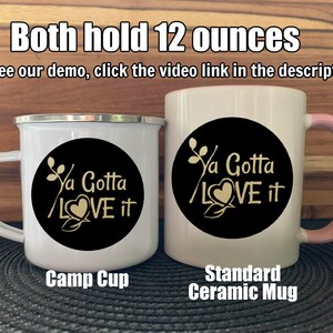 May include: Two mugs, one a white enamel camp cup and the other a white ceramic mug with a pink rim, both with a black circle design that says "Ya Gotta LOVE it" in gold lettering. Both mugs hold 12 ounces.