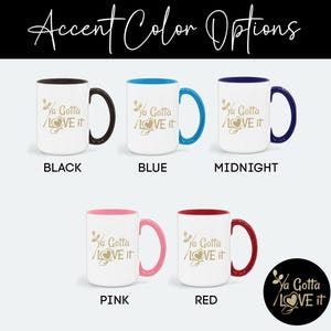 May include: White ceramic mugs with various accent colors, including black, blue, midnight, pink, and red. Each mug features the text "Ya Gotta LOVE it" in gold lettering. The image also includes a black circle with the same text.