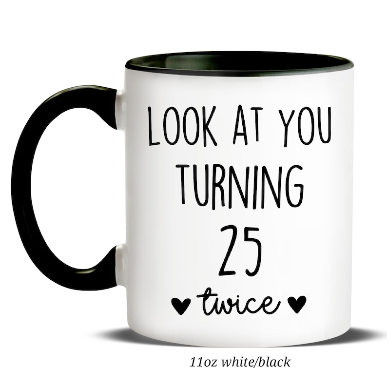May include: White ceramic mug with a black handle and rim. The mug features the text "LOOK AT YOU TURNING 25 twice" in black, with two heart symbols. The bottom of the mug reads "11oz white/black".