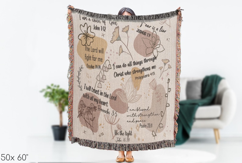 May include: Beige woven throw blanket, 127 x 152 cm, with floral and abstract designs and inspirational quotes. Features fringed edges and text including "Fear is a liar" and "I can do all things".