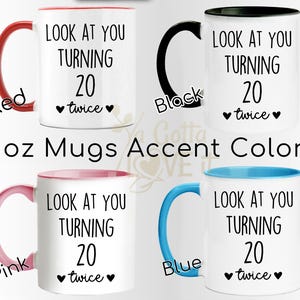 May include: White ceramic mugs with accent colors, featuring the text "LOOK AT YOU TURNING 20 twice" in black. The mugs have red, black, pink, and blue accents. The image also includes the text "11oz Mugs Accent Colors".