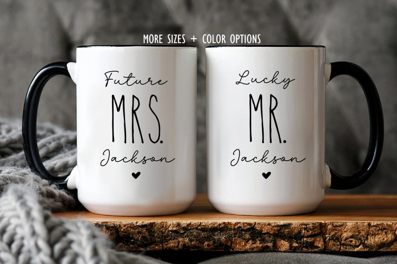 Puede incluir: Dos tazas de cer&aacute;mica blanca con asas y bordes negros. La taza izquierda presenta el texto negro Future MRS. Jackson con un peque&ntilde;o coraz&oacute;n. La taza derecha presenta el texto negro Lucky MR. Jackson con un peque&ntilde;o coraz&oacute;n. Texto arriba: MORE SIZES + COLOR OPTIONS.