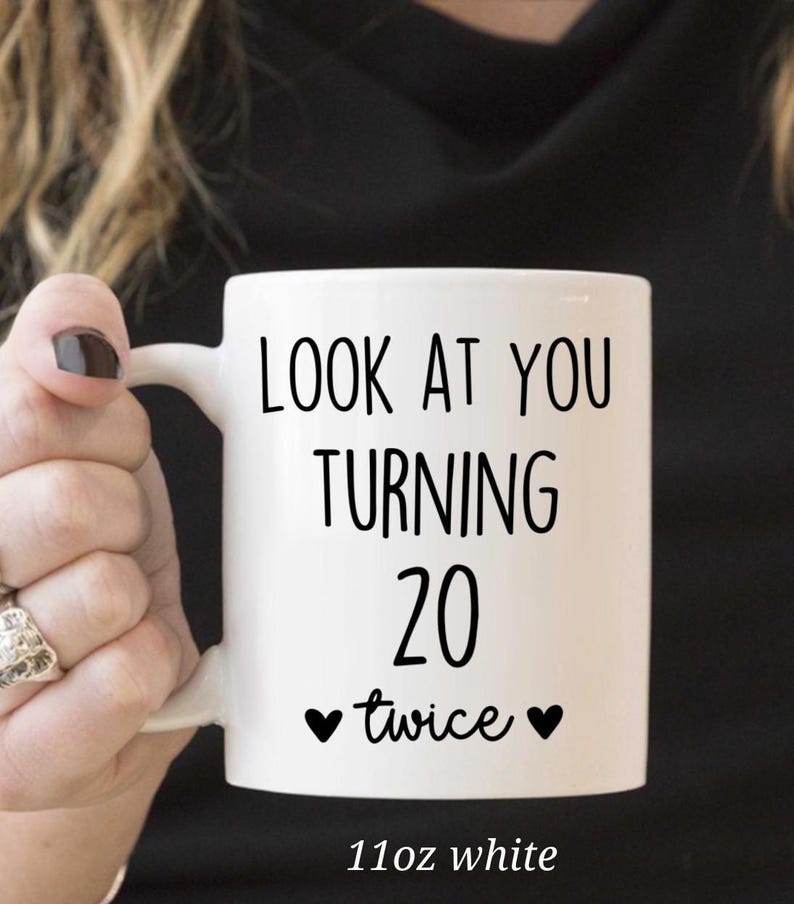 May include: White ceramic mug with the text "LOOK AT YOU TURNING 20 twice" in black. The mug has a capacity of 11oz. A fun gift for a milestone birthday.