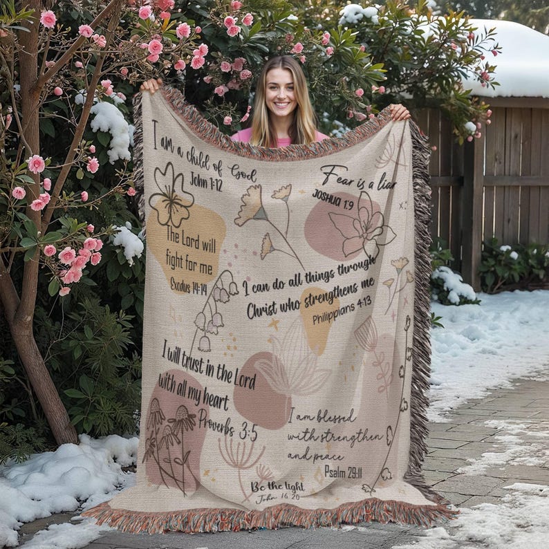 May include: Beige woven throw blanket with floral and botanical designs, and inspirational text. The blanket features quotes from the Bible, including "I am a child of God" and "Fear is a liar."