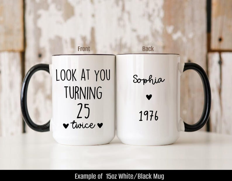 May include: White ceramic mug with a black handle and rim. The front of the mug reads "LOOK AT YOU TURNING 25 twice" with heart symbols. The back of the mug says "Sophia" with a heart and "1976".