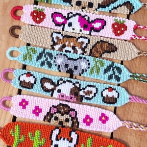 May include: A collection of colorful friendship bracelets with various animal and nature-themed designs. The bracelets are made with colorful embroidery floss and feature designs such as a cow, a llama, a toucan, and a cupcake. The bracelets are displayed on a wooden surface.