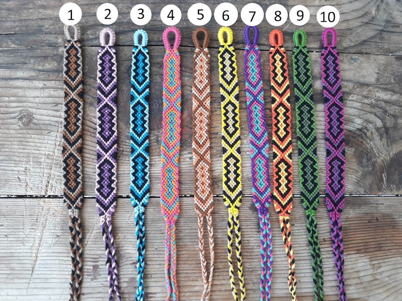 May include: Ten colorful friendship bracelets with different geometric patterns. The bracelets are made with colorful embroidery floss and have a knot at the end. The bracelets are numbered 1 through 10.