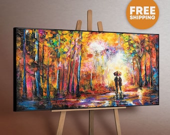 May include: A framed landscape painting on an easel. The artwork shows a colourful forest scene with trees and a couple under an umbrella. The painting has a textured, impressionistic style with a black frame.