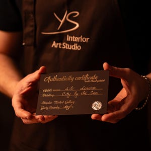 K&ouml;nnte beinhalten: Ein rechteckiges schwarzes Echtheitszertifikat mit goldener Schrift. Der Text lautet Authenticity certificate, Artist's name Lili Lozova, Painting City by the Sea, Director YS Art Gallery und Yury Opansky, inklusive eines runden wei&szlig;en Logos.
