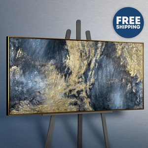 Peut inclure: Une peinture sur toile rectangulaire présentant une composition abstraite texturée de bleu marine profond, de gris anthracite et d'accents de feuilles d'or métalliques. L'œuvre est encadrée d'un cadre fin et sombre sur un chevalet en bois.