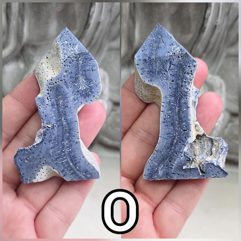 May include: A polished, irregular mineral specimen featuring a deep blue, porous, and fibrous crystalline structure contrasted with sections of light beige, textured stone. The piece displays a pointed top and a jagged, organic silhouette.