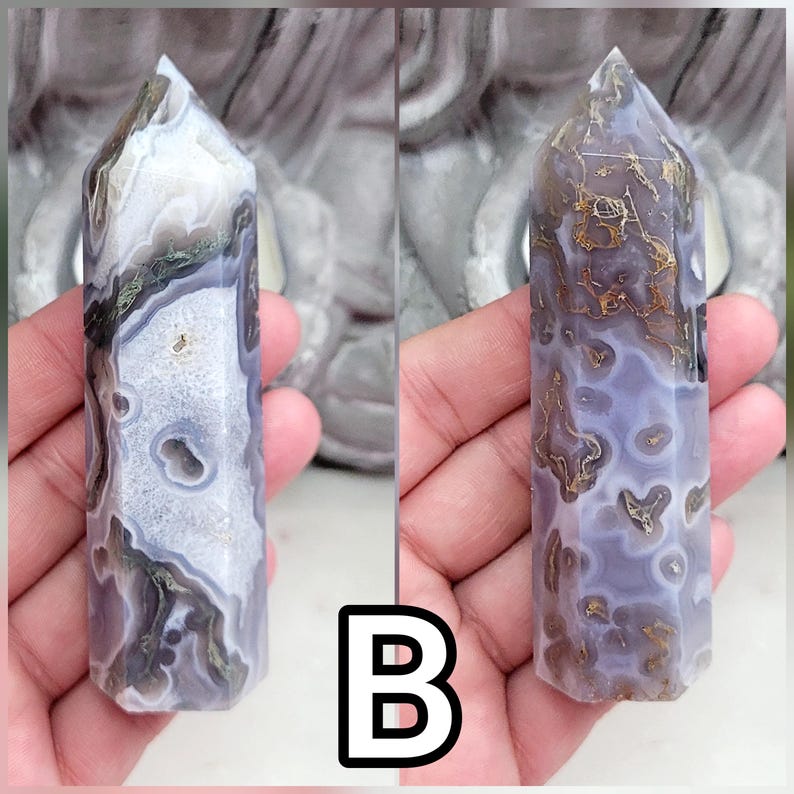 May include: A polished hexagonal crystal tower featuring a translucent lavender and white agate base with intricate brown and gold-toned dendritic inclusions and small geode pockets throughout the stone, displayed in two different views labeled B.