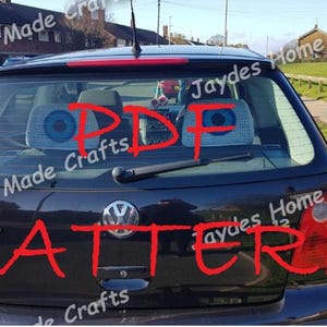 May include: A black car with the words "PDF PATTERN" written in red on the rear window. The words "Jaydes Home Made Crafts" are written in red on the sides of the car.
