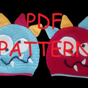 May include: Two crocheted monster hats, one blue and one red, with white eyes, jagged teeth, and colorful horns. The hats have the text "PDF PATTERN" in red across the image. The hats are on a black background.