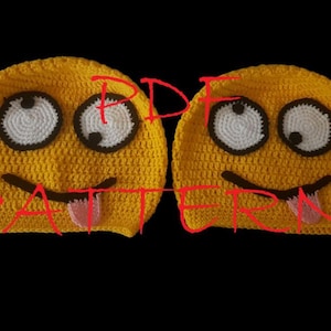 May include: Two yellow crocheted hats with a cartoon emoji face design. Each hat features large white eyes with black pupils, a brown mouth, and a pink tongue sticking out. The hats are set against a black background.