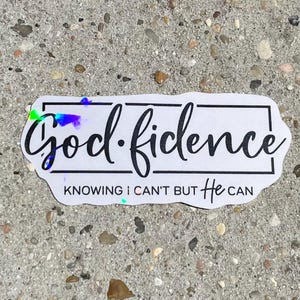 May include: A white sticker with the words "God-fidence" in a black, cursive font, framed by a black rectangle. Below, the text reads "Knowing I can't but He can". The sticker has a holographic sheen.